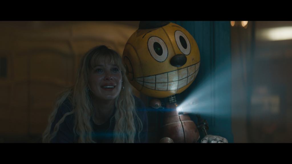 The Electric State. Michelle (Millie Bobby Brown) with Cosmo (voiced by Alan Tudyk) in The Electric State. ™/© 2024 Netflix. Used with permission